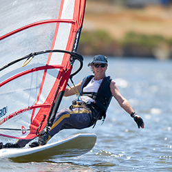 A man windsurfing on shoreline lake