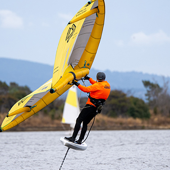 A man in an orange jacket wing foiling