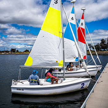 Three boats full of people docked and getting instructions