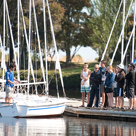 A man giving a large group of people sailing instructions.