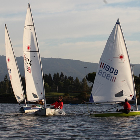 Three boats maneuvering swiftly on shoreline lake